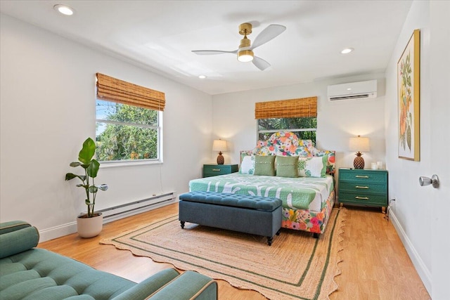 bedroom featuring an AC wall unit, light hardwood / wood-style flooring, a baseboard radiator, and ceiling fan