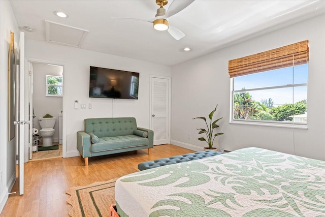 bedroom featuring light wood-type flooring, a closet, ceiling fan, and ensuite bathroom