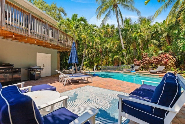 view of pool featuring a patio and a grill