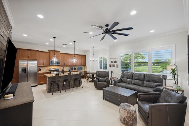 living room with ceiling fan with notable chandelier, ornamental molding, and sink