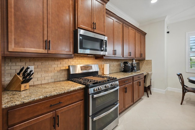 kitchen with light stone counters, ornamental molding, appliances with stainless steel finishes, and tasteful backsplash