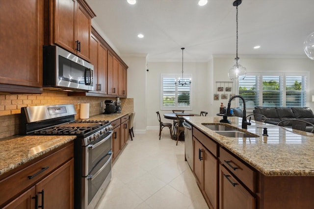 kitchen featuring a healthy amount of sunlight, a kitchen island with sink, sink, and stainless steel appliances