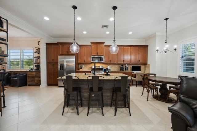 kitchen with pendant lighting, light stone countertops, appliances with stainless steel finishes, tasteful backsplash, and a breakfast bar area