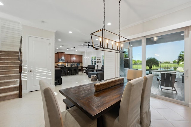 tiled dining space featuring ceiling fan and crown molding