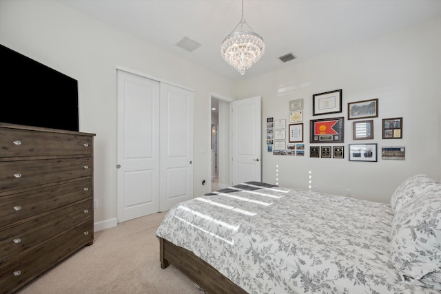 carpeted bedroom with a closet and an inviting chandelier