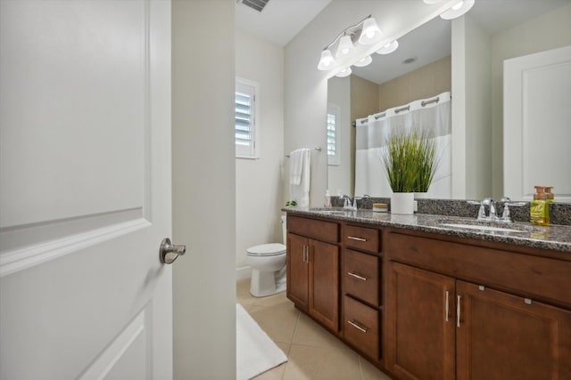 bathroom featuring tile patterned flooring, vanity, toilet, and walk in shower