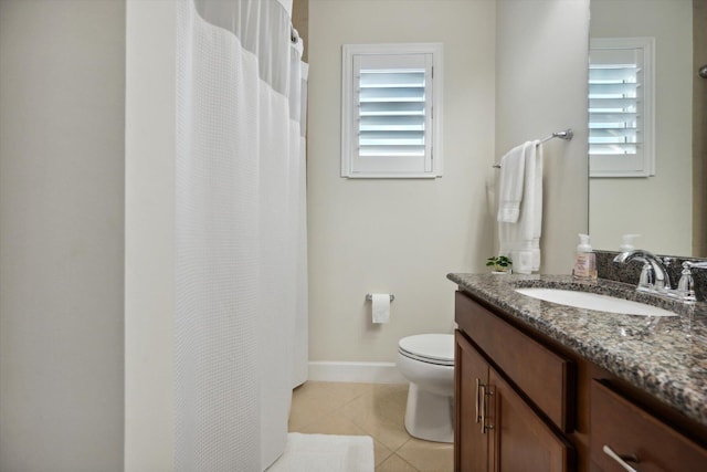 bathroom featuring tile patterned floors, a wealth of natural light, vanity, and toilet