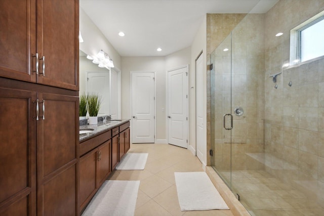 bathroom featuring tile patterned flooring, vanity, and a shower with door