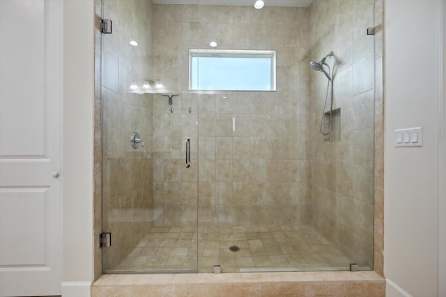 bathroom featuring a shower with shower door