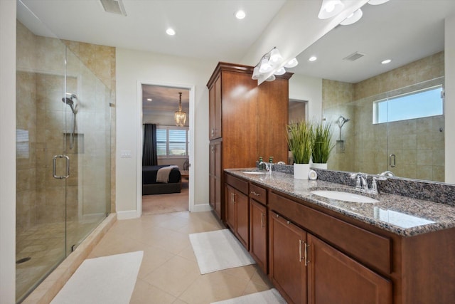 bathroom featuring tile patterned floors, vanity, a healthy amount of sunlight, and a shower with shower door