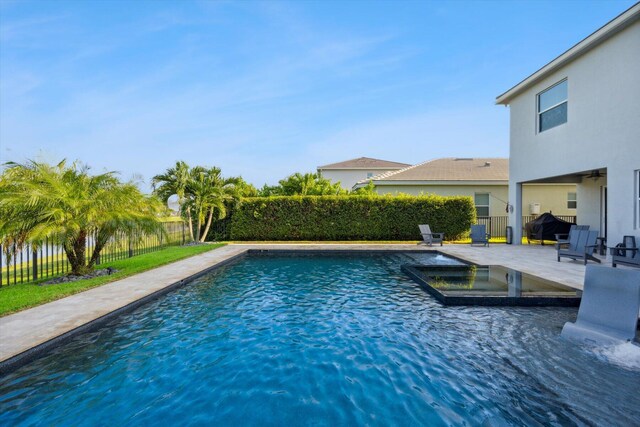 view of pool featuring a water view, an in ground hot tub, and a patio