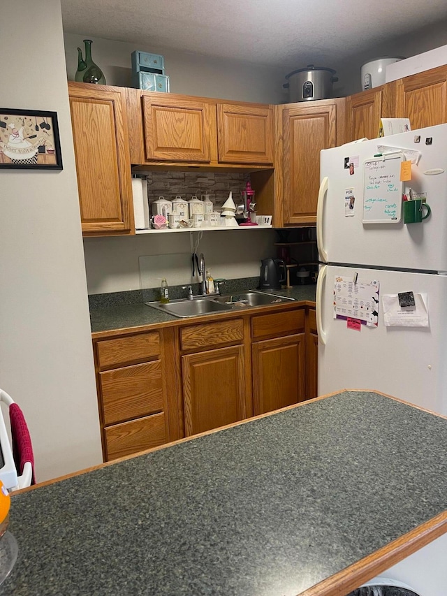 kitchen featuring sink, decorative backsplash, and white fridge