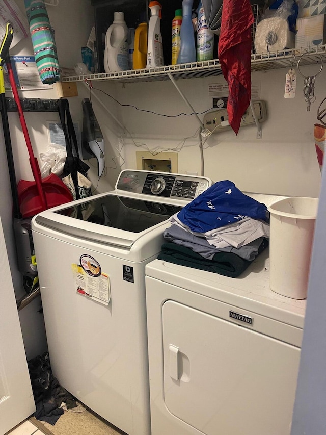 clothes washing area featuring washer and clothes dryer