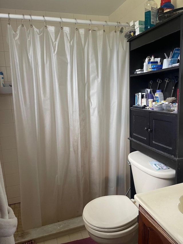 bathroom with vanity, a shower with curtain, toilet, and tile patterned flooring