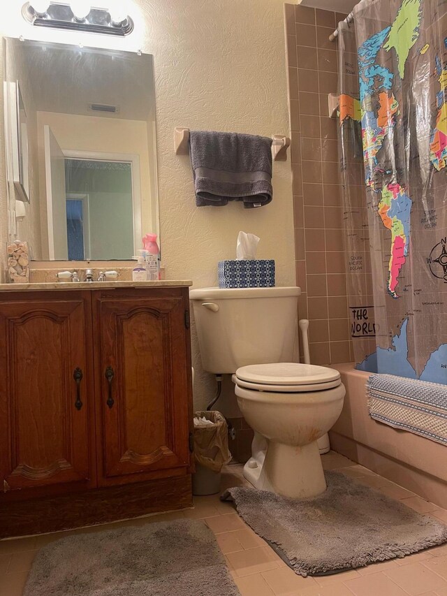 full bathroom featuring tile patterned flooring, shower / bath combo, vanity, and toilet