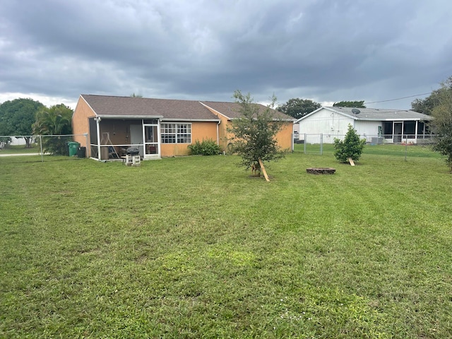 back of property with a sunroom and a lawn