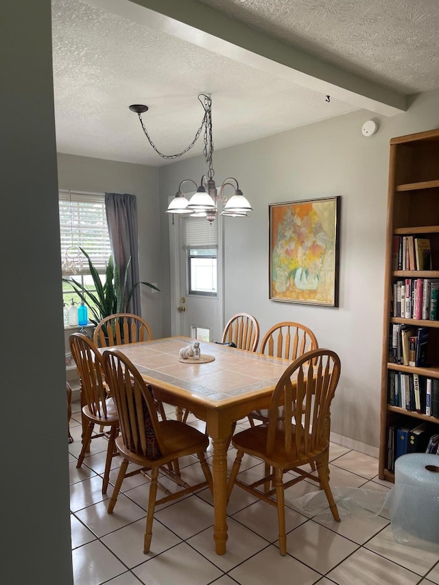 tiled dining room featuring beam ceiling, a chandelier, and a textured ceiling