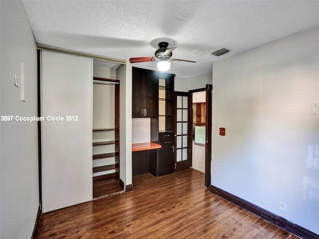 unfurnished bedroom with a textured ceiling, ceiling fan, and hardwood / wood-style floors