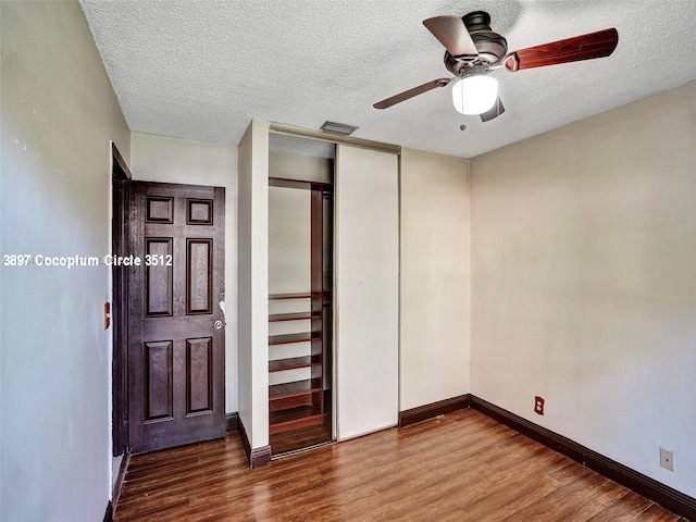 interior space with ceiling fan, hardwood / wood-style flooring, a textured ceiling, and a closet