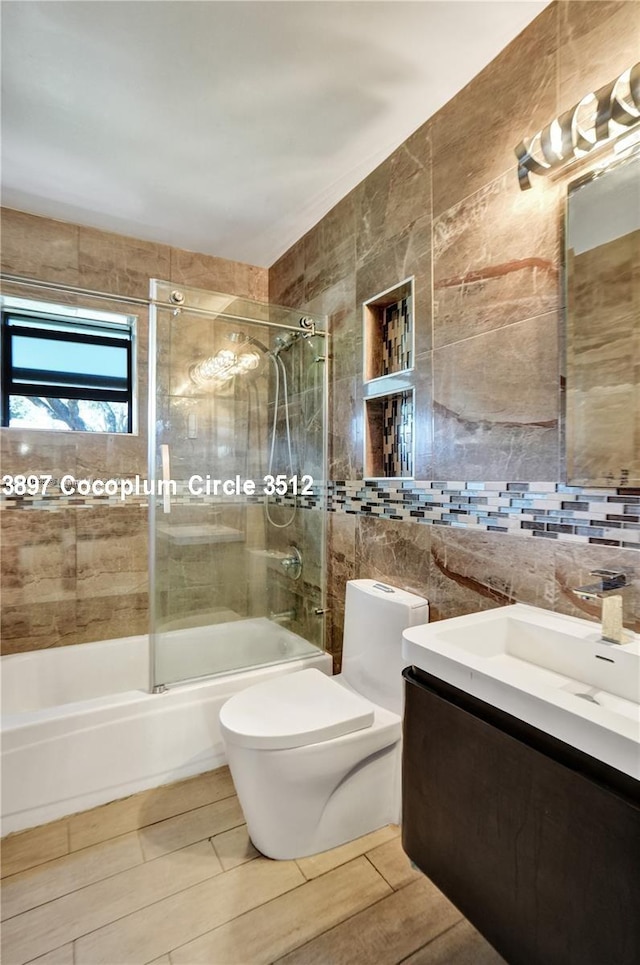 full bathroom featuring tiled shower / bath, tile patterned floors, vanity, and tile walls