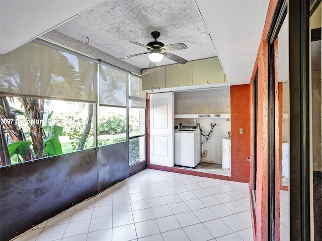 unfurnished sunroom with ceiling fan, a wealth of natural light, and washer / dryer