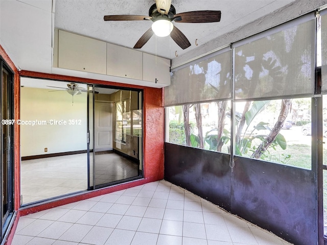 unfurnished sunroom featuring ceiling fan