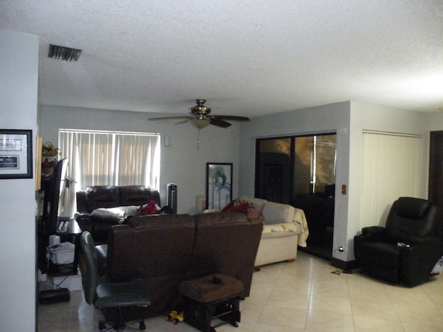 tiled living room featuring a textured ceiling and ceiling fan