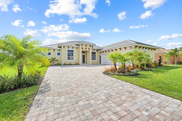 mediterranean / spanish-style home featuring a front lawn and a garage