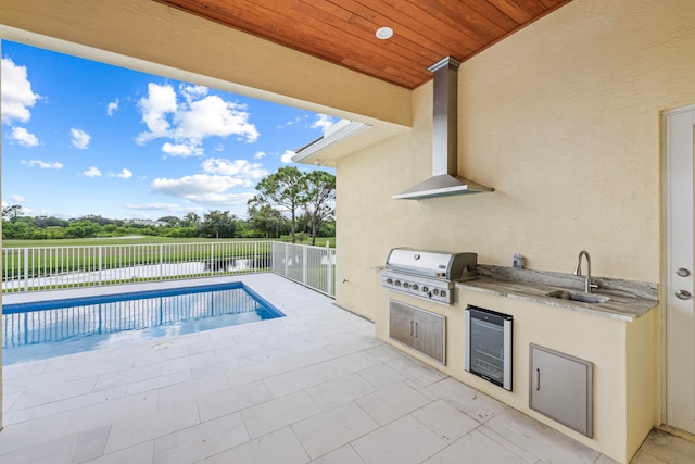 view of pool with sink, grilling area, a patio area, and an outdoor kitchen