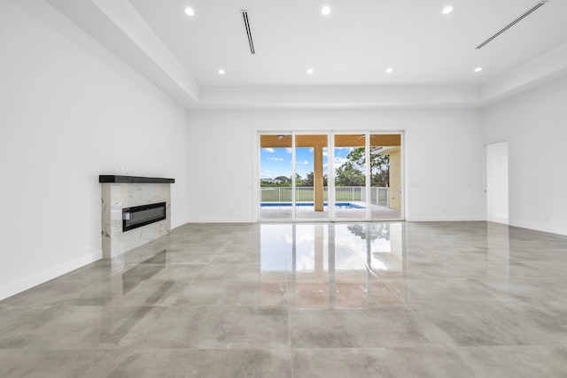 unfurnished living room with light tile patterned flooring, a fireplace, and a tray ceiling