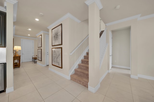 stairway with ornate columns, ornamental molding, and tile patterned flooring