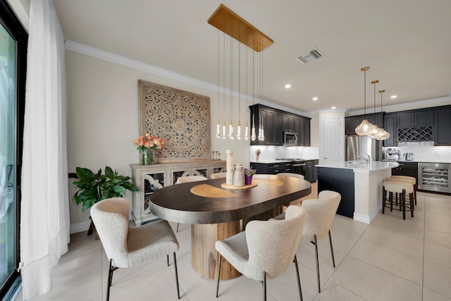 tiled dining room with crown molding and wine cooler