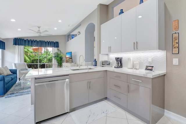 kitchen featuring sink, tasteful backsplash, kitchen peninsula, and stainless steel dishwasher