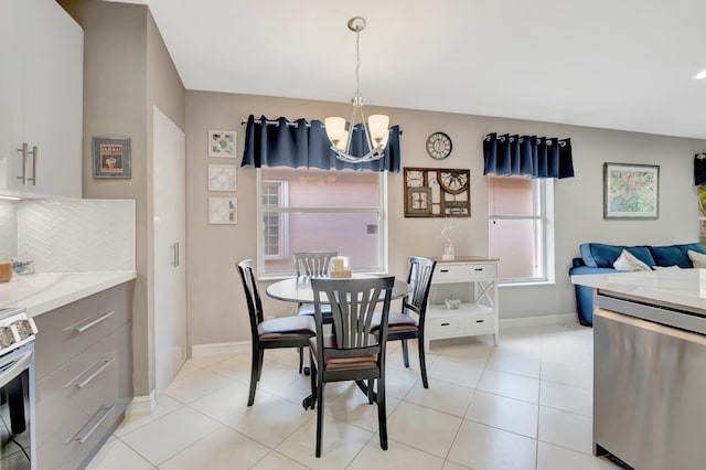 tiled dining room featuring plenty of natural light and a chandelier