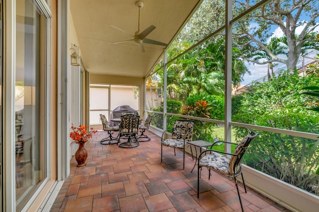 sunroom with ceiling fan and vaulted ceiling