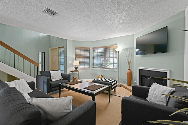 living room featuring a textured ceiling and carpet floors