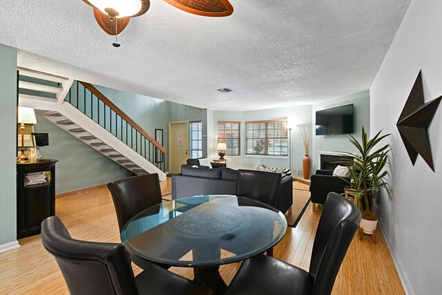 dining area featuring a textured ceiling and light hardwood / wood-style flooring