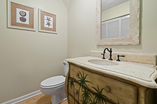 bathroom featuring toilet, hardwood / wood-style flooring, and vanity