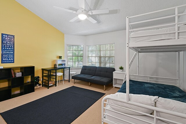 bedroom featuring a textured ceiling, ceiling fan, and light colored carpet