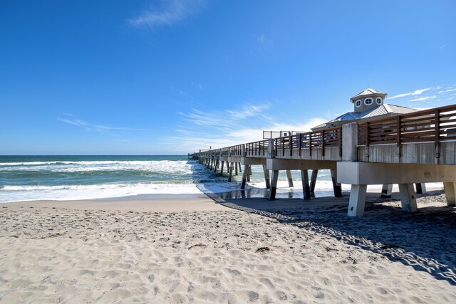 view of dock featuring a beach view and a water view