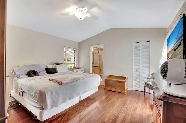 bedroom with lofted ceiling, ceiling fan, connected bathroom, wood-type flooring, and a closet