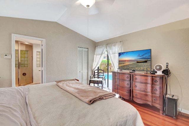 bedroom with a closet, access to outside, light hardwood / wood-style flooring, vaulted ceiling, and ceiling fan