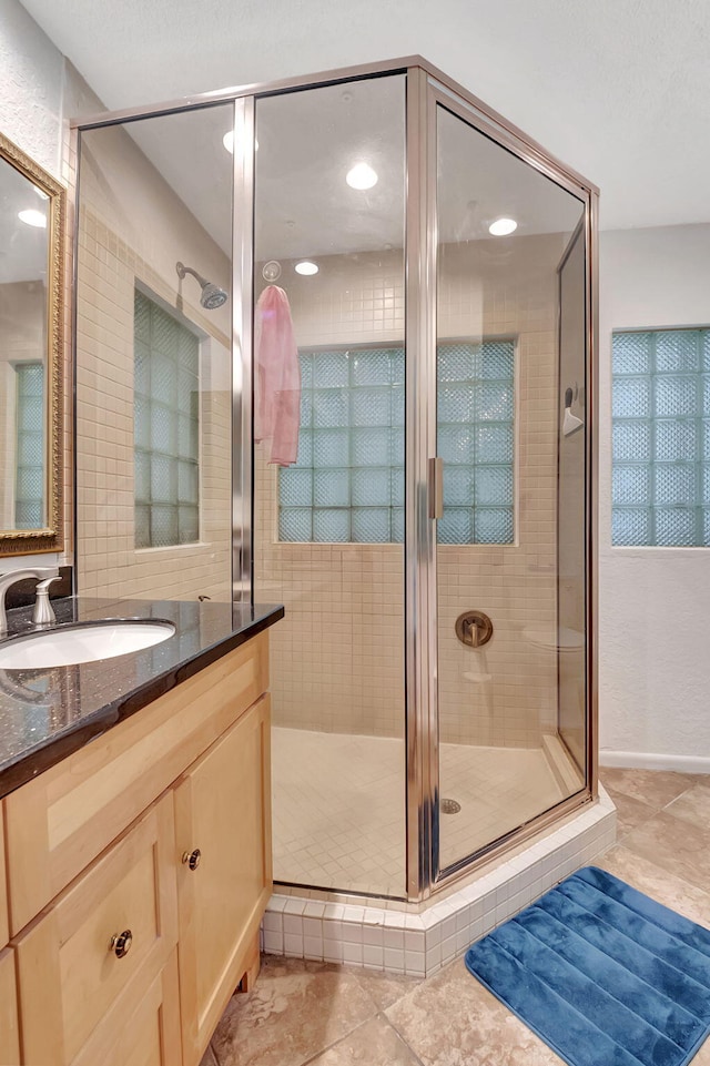 bathroom with vanity, tile patterned floors, and a shower with door