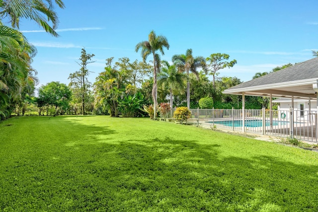 view of yard with a fenced in pool and fence