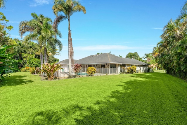 back of house featuring a yard and fence