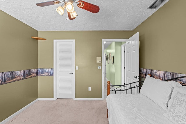 bedroom with visible vents, baseboards, carpet, and a textured ceiling