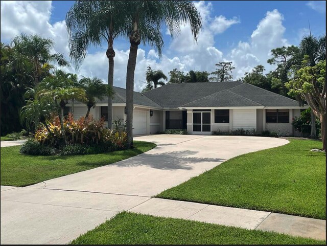 ranch-style house featuring a front lawn and a garage