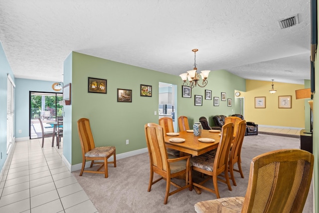 dining space featuring light tile patterned floors, visible vents, vaulted ceiling, a textured ceiling, and a chandelier