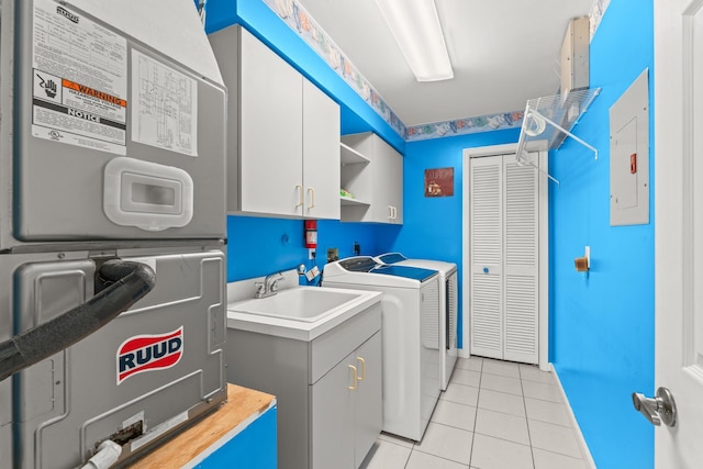 washroom with a sink, light tile patterned floors, cabinet space, and washing machine and clothes dryer