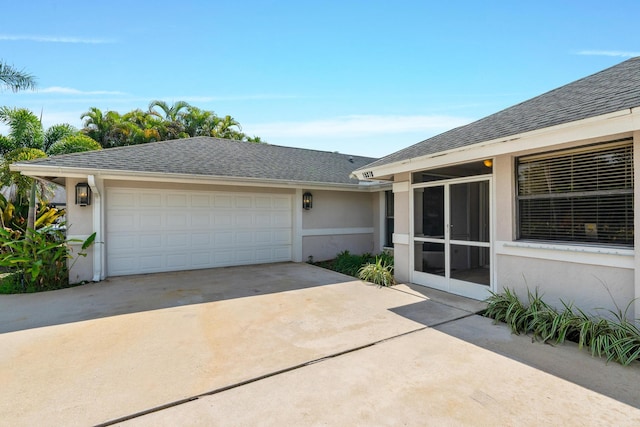 view of front of property with a garage, stucco siding, driveway, and roof with shingles